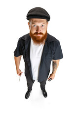 High angle view of red bearded man, barber or hair cutter in black cap isolated on white studio background. Holding his working equipment.