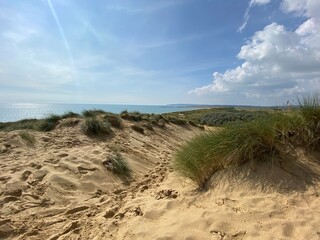 Camber sands East Sussex UK - view of Camber Sand dunes with sky and sea dunes held together with grasses stopping sand blowing away