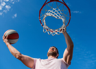 summer activity. strong man with basketball ball on court. professional basketball player © Olena