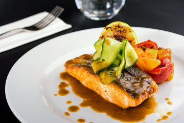 Grilled salmon fillet with vegetables mix. dark background