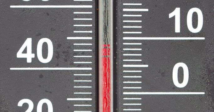Thermometer cooling down and freezing on 0 Celsius with camera follow
