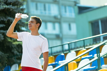 Young Caucasian man, male athlete, runner isolated at public stadium, sport court or running track outdoors. Summer sport games.