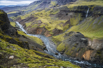 Highlands of Iceland. River Fossa stream in the Landmannalaugar canyon valley. Hills and cliffs are...