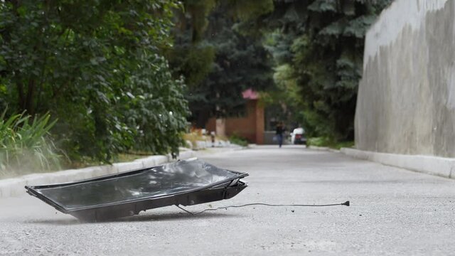 Modern flat screen TV falls on the asphalt from a height and crashes in slow motion, 180 fps