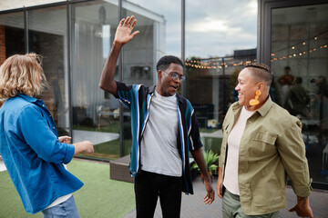 Obraz premium Three young people having fun while enjoying outdoor party at rooftop, copy space