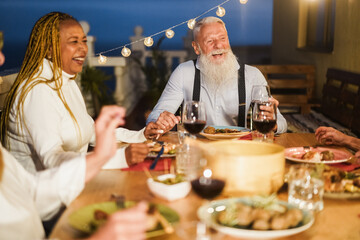 Senior people having fun at patio dinner party - Focus on hipster male face