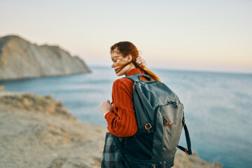 woman hiker with a backpack on her back walking in the mountains adventure fresh air