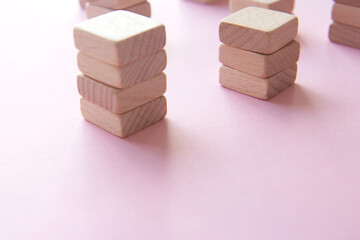 Set of stacks of wooden cubes on a pink background. Concept of team building, teamwork