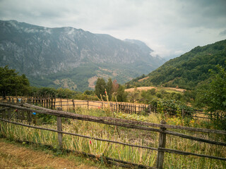 Blick über einen Bauerngarten auf die nebelverhangenen Berge des rumänischen Nationalparks Domogled-Valea Cerne. Nahe des Dorfes Inelet aufgenommen.