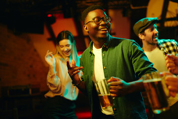 Cheerful African American man dancing during his night out in a pub.