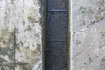 Textured surface of gray concrete wall with scratches and cracks