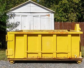 Isolated yellow industrial dumpster.
