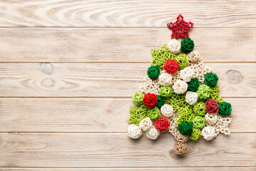 Christmas tree made from colored handmade ball decoration on colored background, view from above. New Year minimal concept with copy space