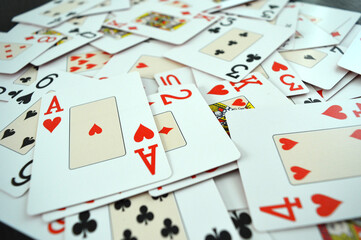 Poker Game Cards - Photo of cards mixed on a table showing all suits - Hearts, Spades, Diamonds and Clubs