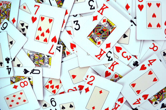 Poker Game Cards - Photo of cards mixed on a table showing all suits - Hearts, Spades, Diamonds and Clubs