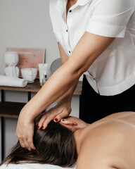 Obraz na płótnie Canvas Hands of a female professional facial masseur at work in a beauty salon