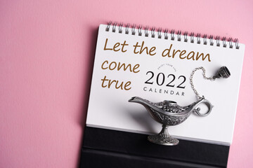 calendar 2022 with magical mysterious aladdin lamp on pink background
