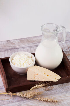Milk and dairy products stand in a brown wooden tray in a rustic style