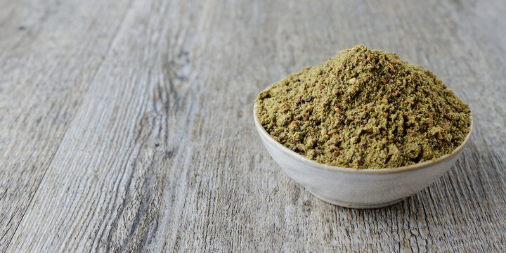 Green Za'atar spice blend heap in a bowl. Traditional Middle East zaatar condiment.