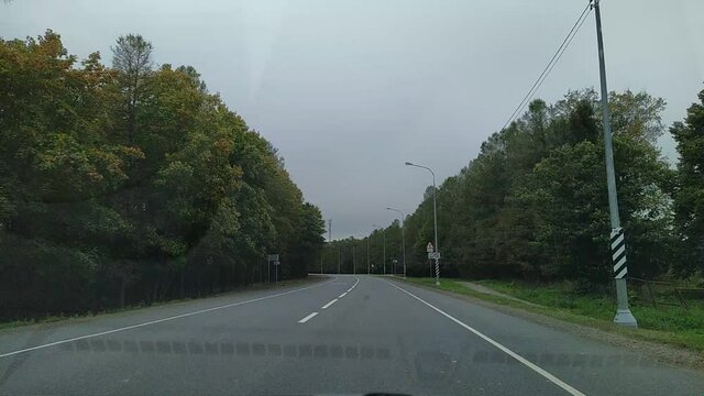 car drives in the daytime with horizon on gray sky. time lapse video inside view