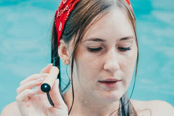 Woman smoking with electronic cigarette. Young woman smoking electronic cigarette in outdoors pool