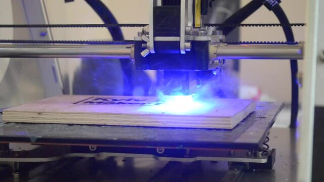 Laser engraving on wood. 3D printer laser beam burns the pattern