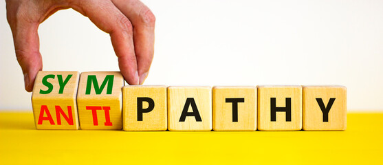 From antipathy to sympathy. Businessman turns cubes and changes the word 'antipathy' to 'sympathy'....