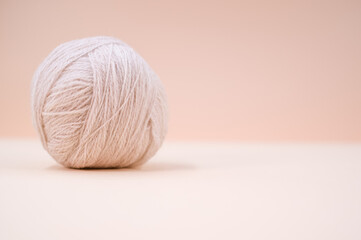 Vertical shot of soft gray yarn balls on a beige background