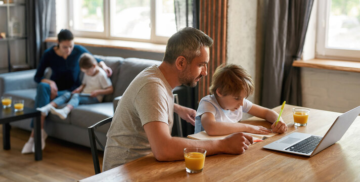 Banner shot of caring father help son with school assignment