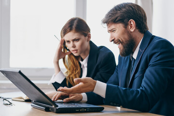 business man and woman sitting in front of a laptop teamwork technologies