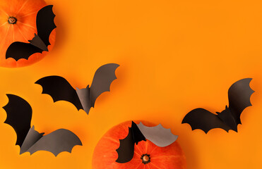 Halloween composition of pumpkins and cartoon black bats on orange background. Bright holiday...