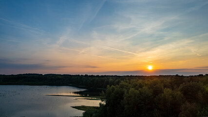 Aerial view of a rural landscape during sunrise in Belgium. Rural farm, corn fields, green fields, sunlight and fog. Belgium, Europe. High quality photo