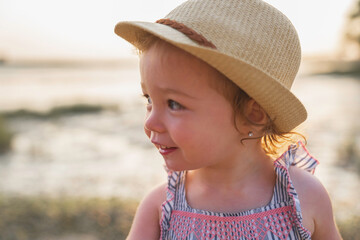 Baby outdoors enjoying nature on the sunset beach