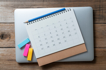close up of calendar and computer on the wooden table background, planning for business meeting or...