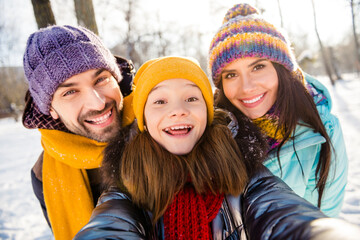 Photo of cheerful family mom dad kid happy positive smile make selfie have fun walk park winter snowy
