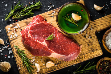 Beef steak ribeye at cutting board with spices. Dry aged meat.