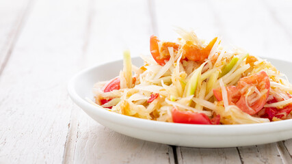Som Tum Thai, Som Tam Thai, Thai food, spicy papaya salad with, tomato, lime and chilli topping with dried shrimp on white old wood texture background, light and airy food photography