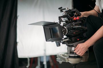 Professional cinema and video camera on the set. Shooting shift, lighting fixtures, shooting equipment and the team.
