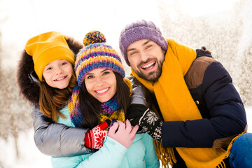 Photo of cheerful family mommy daddy daughter happy positive smile hug cuddle embrace winter trip vacation outdoors