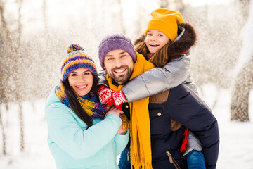 Photo of cheerful family mom dad daughter piggyback happy positive smile fly air snow winter nature outdoors