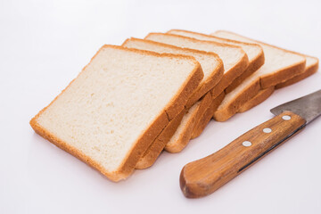 white slices of bread and a knife on a white background.