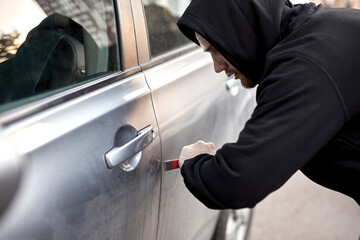 Unrecognizable Car thief steal car breaking door criminal job burglar Hijacks Auto thief is trying...