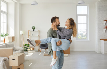 Romantic portrait of joyful and satisfied young couple in love moving to their new home. Loving...