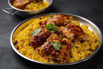 The national Saudi Arabian dish chicken kabsa with roasted chicken quarter and almonds, raisins,...