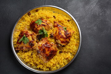 The national Saudi Arabian dish chicken kabsa with roasted chicken quarter and almonds, raisins, garlic and biryani rice