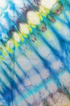Close up of a colorful tie dye abstract background. Hand dyed on cotton fabric texture backdrop.