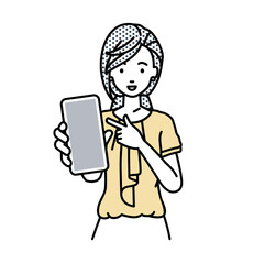 立ってスマートフォンを指差してこちらに向けて見せているオフィスカジュアルの女性