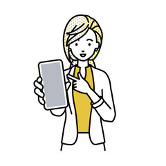 立ってスマートフォンを指差してこちらに向けて見せているジャケットの女性