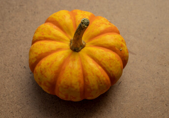 Close-up macro photo of a pumpkin in orange and yellow hues, isolated from the background.