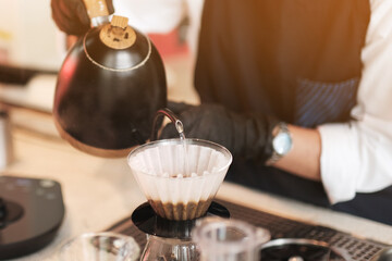 Barista making drip coffee in a cafe